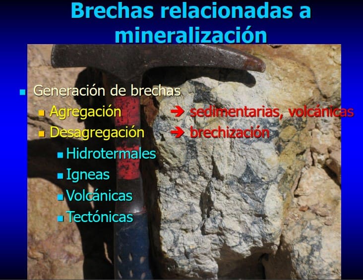 Sección delgada microscópica mostrando la textura de una brecha mineralizada, con fragmentos angulosos de diferentes rocas y una matriz rica en minerales de sulfuro.