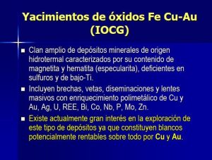 Sección geológica transversal de un yacimiento IOCG mostrando la mineralización de óxidos de hierro, sulfuros de cobre y las zonas de alteración hidrotermal asociadas.